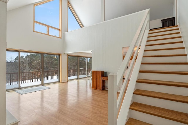 interior space with a towering ceiling and light hardwood / wood-style flooring