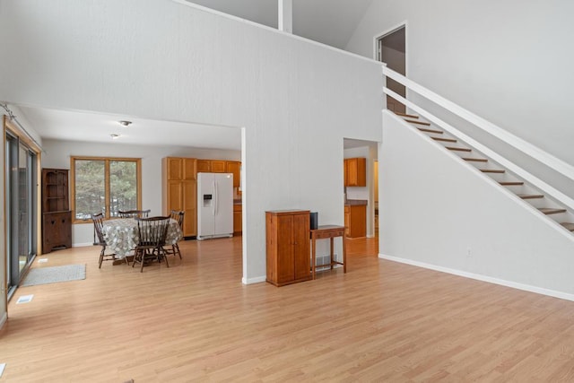 living room featuring a towering ceiling and light wood-type flooring