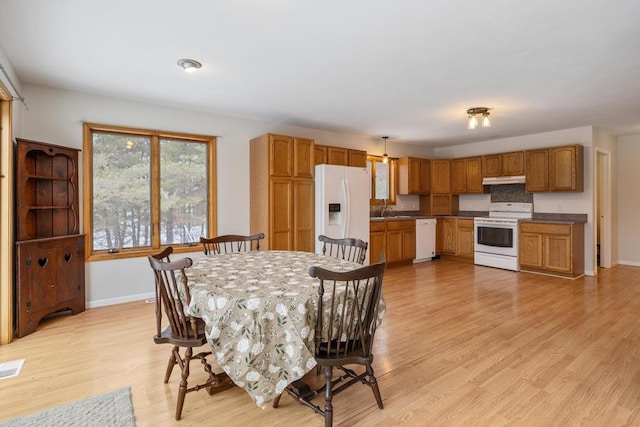 dining space with sink and light hardwood / wood-style flooring