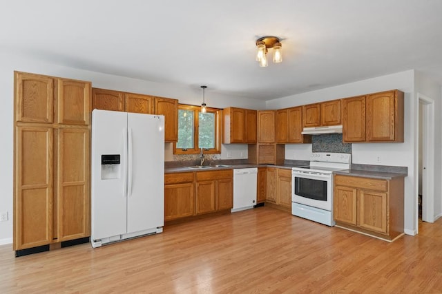 kitchen featuring white appliances, decorative light fixtures, light hardwood / wood-style floors, and sink