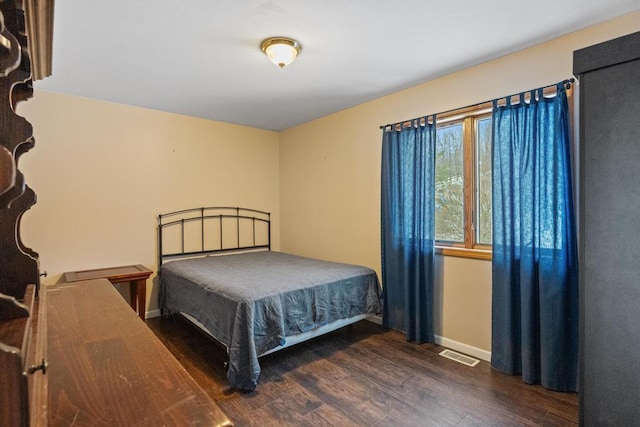 bedroom with dark hardwood / wood-style flooring