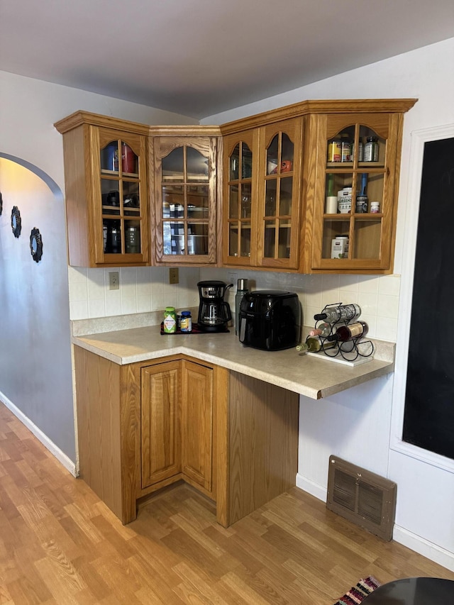 kitchen featuring tasteful backsplash and light hardwood / wood-style floors