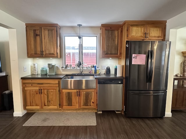 kitchen with stainless steel appliances, dark hardwood / wood-style floors, decorative light fixtures, and sink