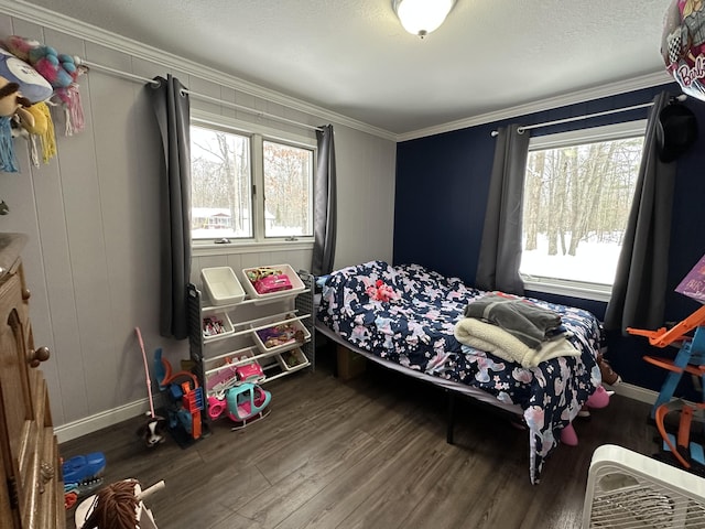 bedroom featuring multiple windows, hardwood / wood-style flooring, ornamental molding, and a textured ceiling