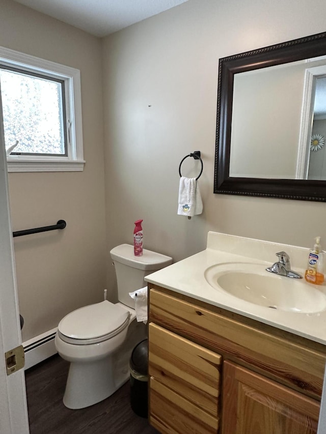 bathroom with vanity, hardwood / wood-style floors, a baseboard radiator, and toilet