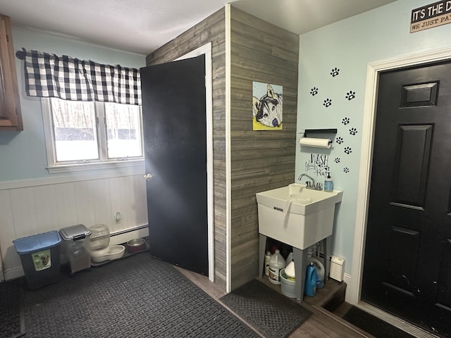 bathroom with hardwood / wood-style flooring, wooden walls, and baseboard heating