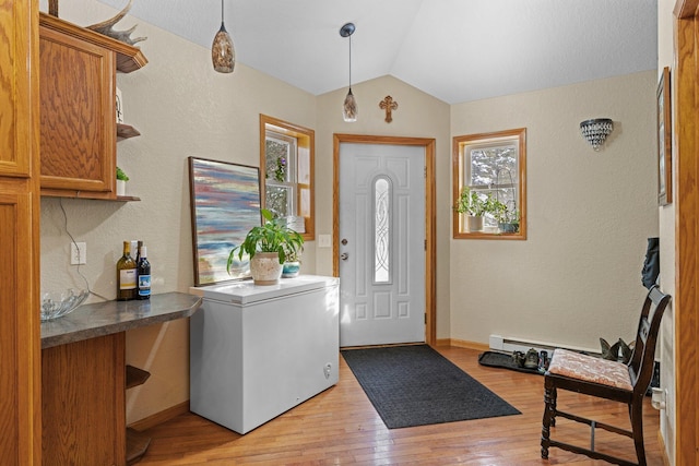 foyer entrance with lofted ceiling and light hardwood / wood-style flooring