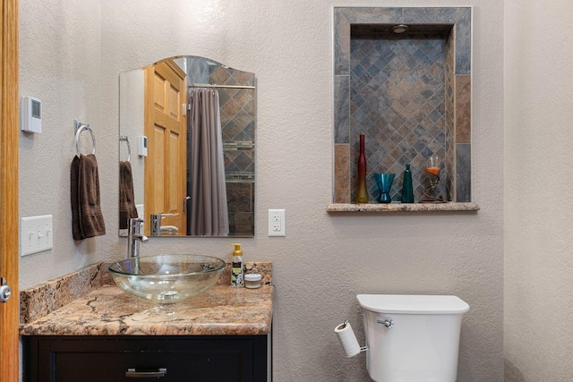 bathroom featuring a shower with curtain, vanity, and toilet