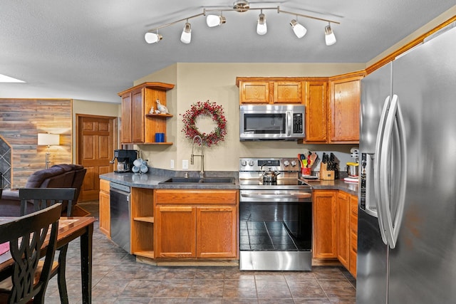 kitchen with sink, a textured ceiling, and appliances with stainless steel finishes