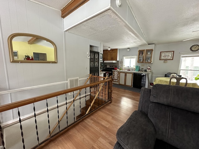 living room with sink, a textured ceiling, and light wood-type flooring