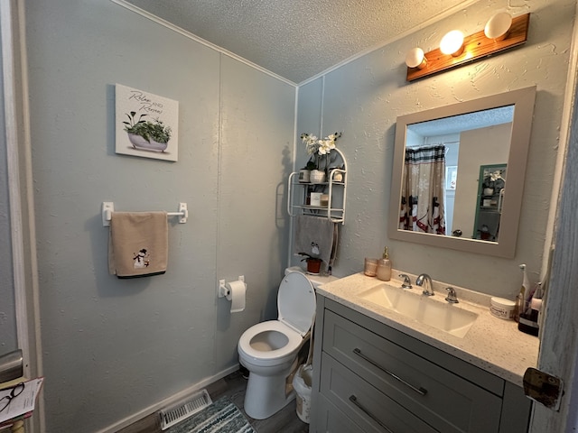 bathroom with vanity, toilet, and a textured ceiling