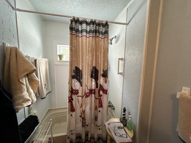 bathroom featuring shower / bath combination with curtain and a textured ceiling