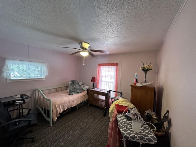 bedroom with ceiling fan, carpet floors, and a textured ceiling