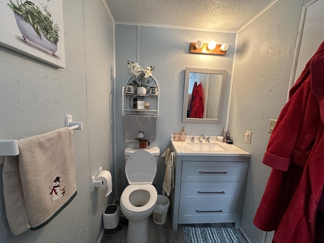 bathroom featuring vanity, hardwood / wood-style flooring, toilet, and a textured ceiling