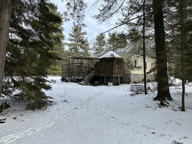 snow covered rear of property with a deck