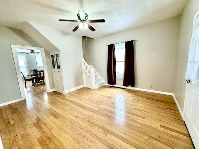 unfurnished room with ceiling fan, light hardwood / wood-style flooring, and a textured ceiling