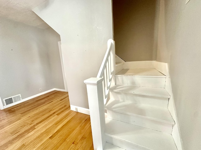 staircase with hardwood / wood-style flooring