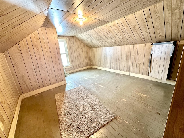 additional living space featuring wooden ceiling, lofted ceiling, hardwood / wood-style floors, and wood walls