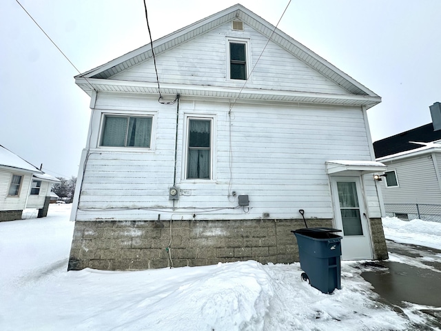 view of snow covered rear of property