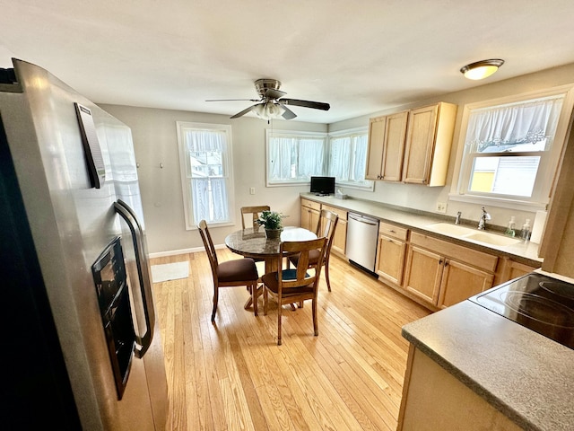 kitchen featuring sink, light hardwood / wood-style flooring, light brown cabinets, and appliances with stainless steel finishes