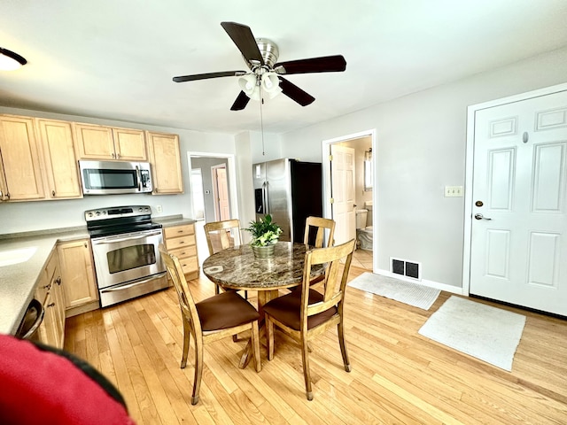 kitchen with stainless steel appliances, light hardwood / wood-style floors, ceiling fan, and light brown cabinets