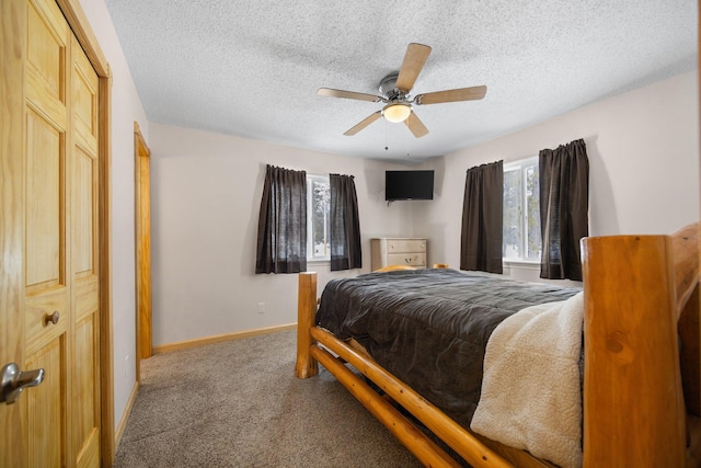 carpeted bedroom featuring ceiling fan and a textured ceiling