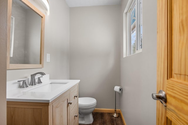 bathroom with vanity, toilet, and hardwood / wood-style floors