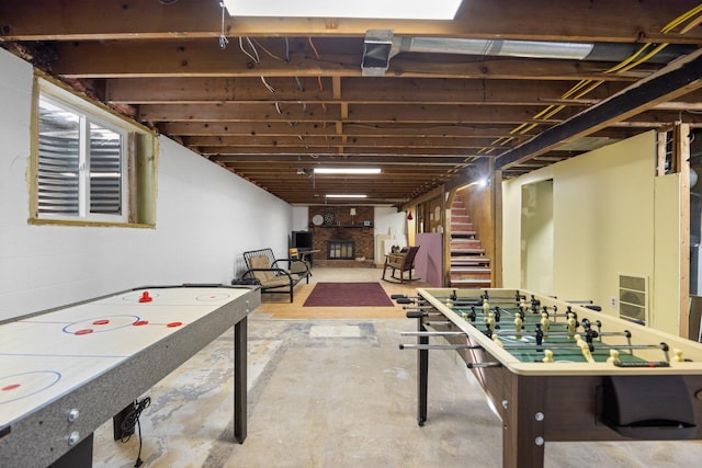 rec room with concrete flooring and a large fireplace