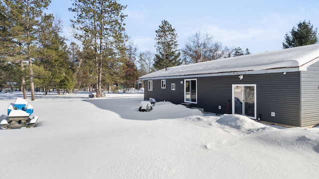 view of snow covered back of property