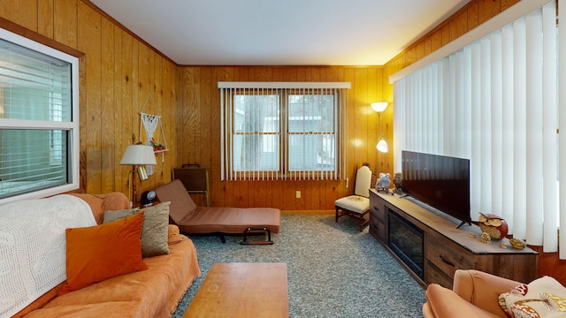 sitting room with carpet floors, wooden walls, and crown molding