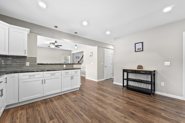 kitchen with white cabinetry, decorative light fixtures, dark stone counters, and decorative backsplash