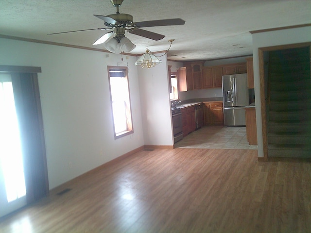 kitchen featuring sink, crown molding, stainless steel fridge, stove, and light hardwood / wood-style floors