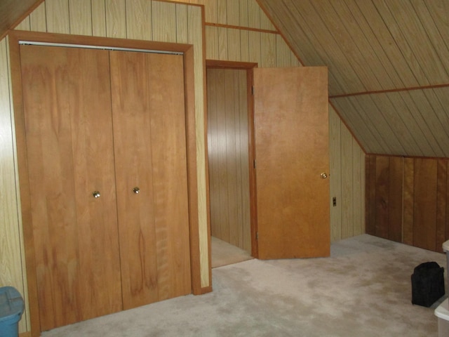 bonus room with light carpet, vaulted ceiling, and wooden walls