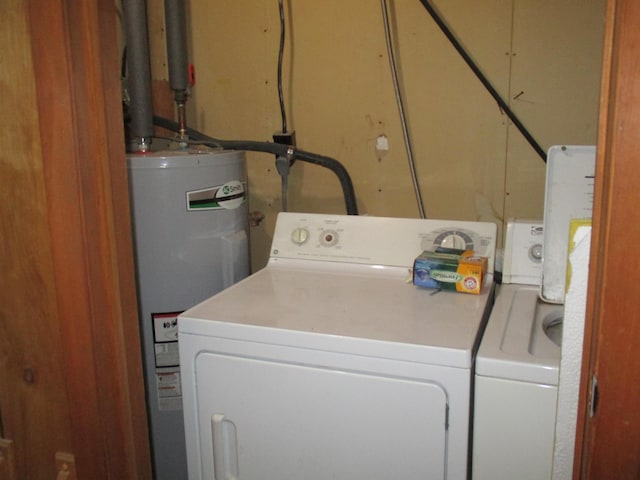 laundry area with washing machine and clothes dryer and water heater