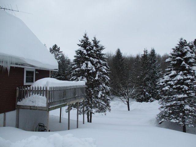 snowy yard featuring a wooden deck