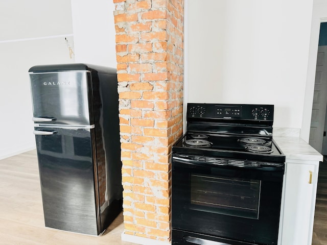 kitchen with black electric range oven and light hardwood / wood-style flooring