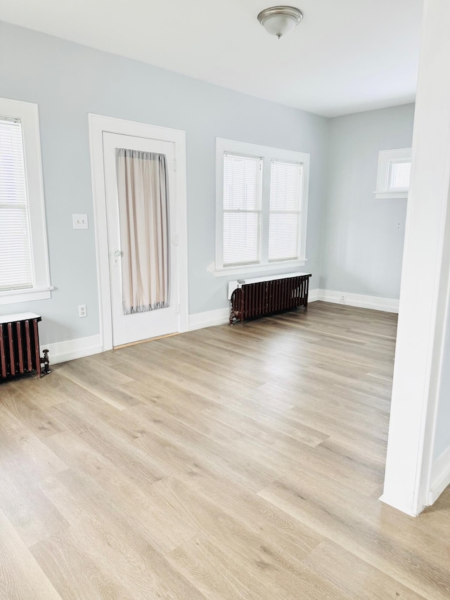 empty room with radiator and light hardwood / wood-style floors