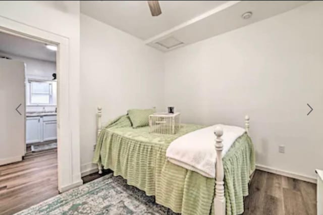 bedroom with white refrigerator, ceiling fan, and wood-type flooring