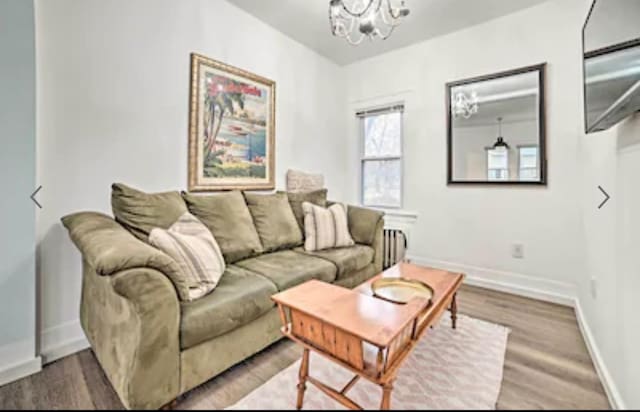 living room with hardwood / wood-style floors and a chandelier