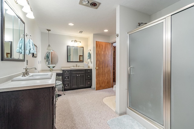 bathroom featuring vanity, a shower with shower door, and toilet