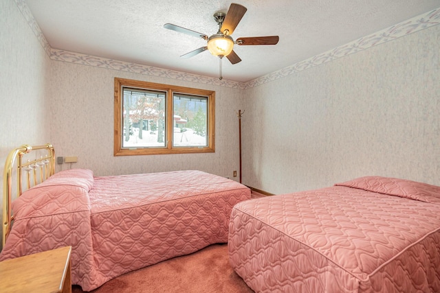 carpeted bedroom featuring ceiling fan and a textured ceiling