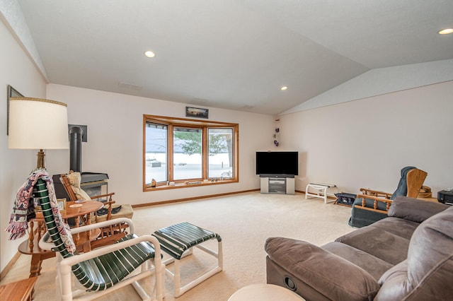 carpeted living room featuring vaulted ceiling and a wood stove