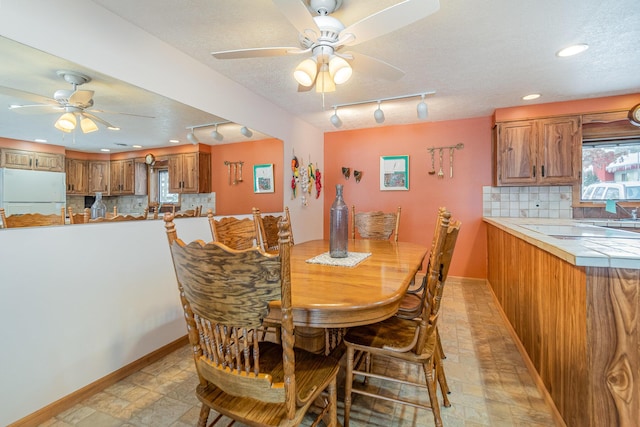 dining area with a textured ceiling and ceiling fan