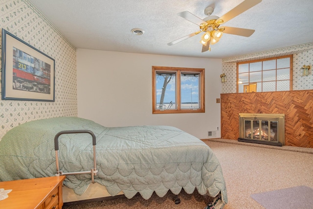 carpeted bedroom with ceiling fan, multiple windows, and a textured ceiling