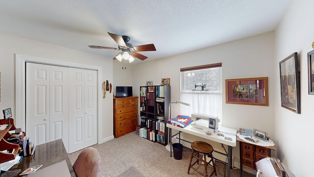 carpeted home office featuring ceiling fan