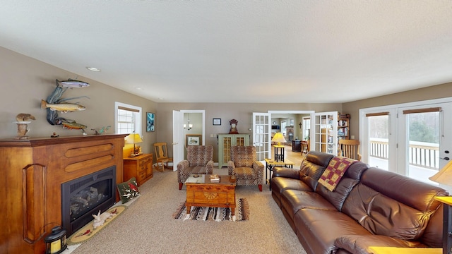 living area featuring french doors, light colored carpet, and a fireplace