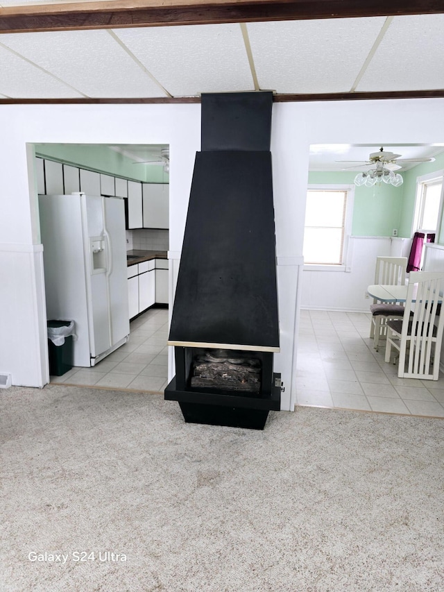 living room with a wood stove, light carpet, and a chandelier