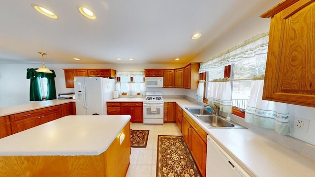 kitchen featuring light countertops, white appliances, a sink, and a center island