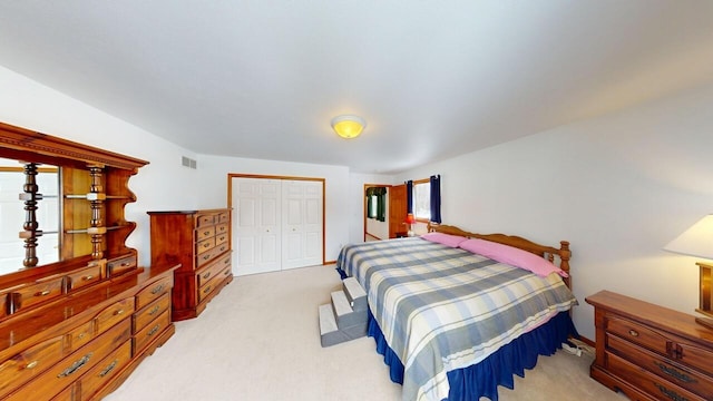 bedroom featuring a closet, visible vents, and light colored carpet