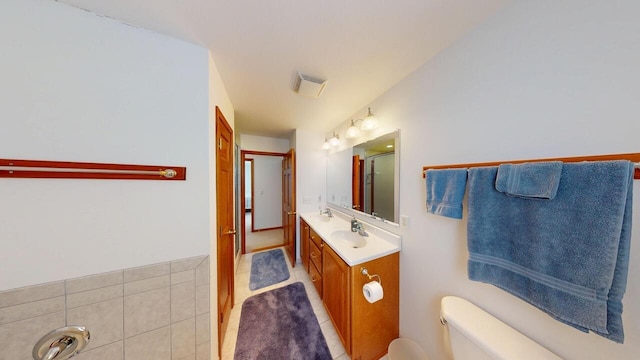 bathroom featuring toilet, vanity, and visible vents